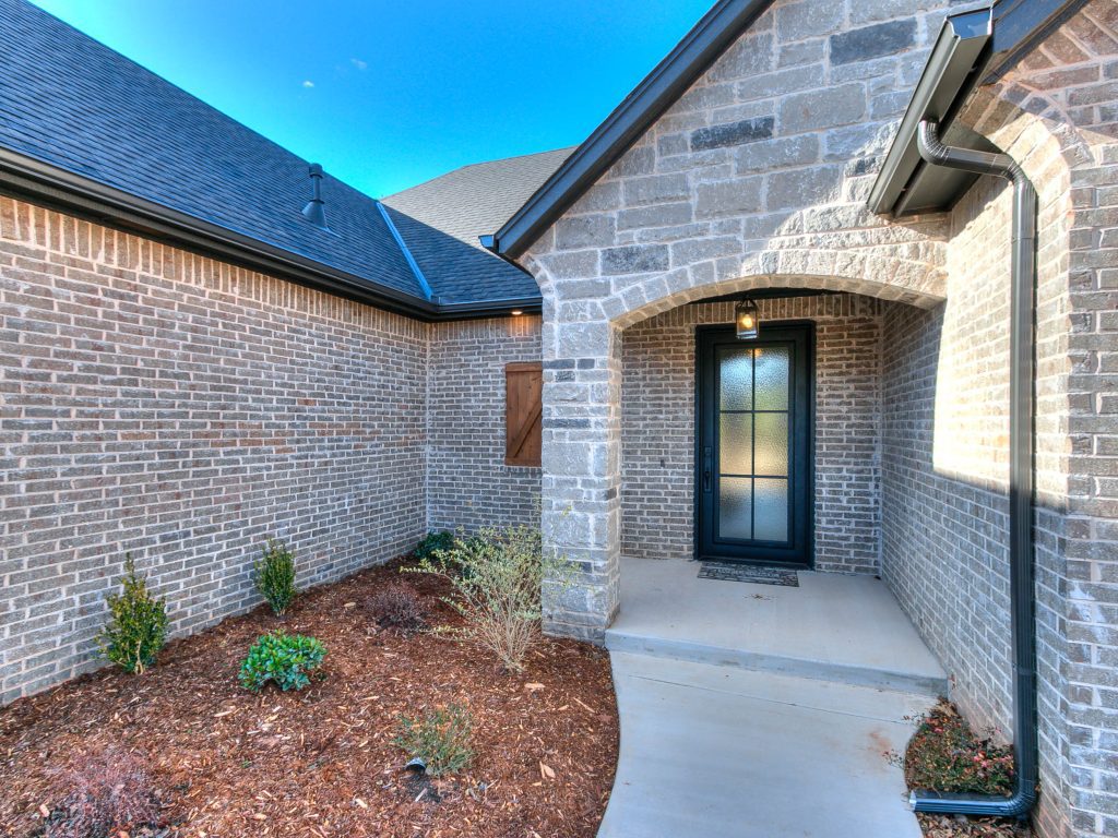 exterior view of front porch, door, and flowerbed