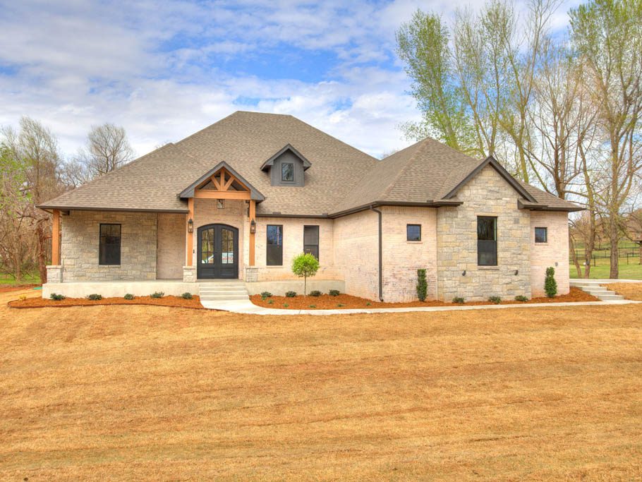 The exterior of a single story house with light red and light brown brick.